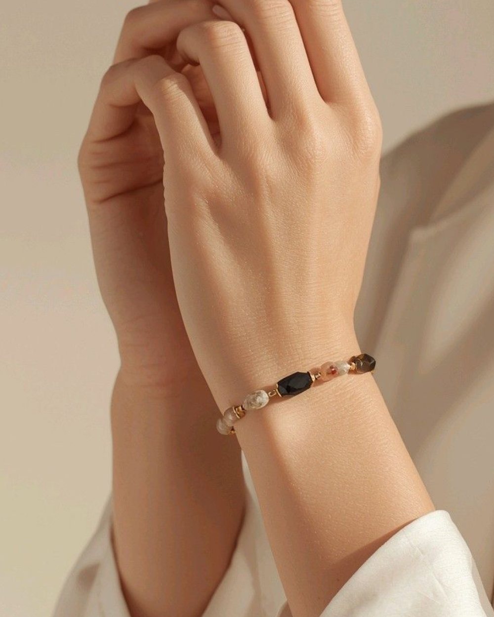 Pulseira folheada com pedras naturais no pulso